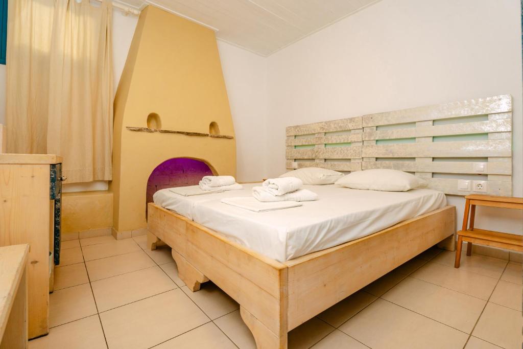 a bedroom with a large bed with a wooden frame at Fanari Art in Ios Chora