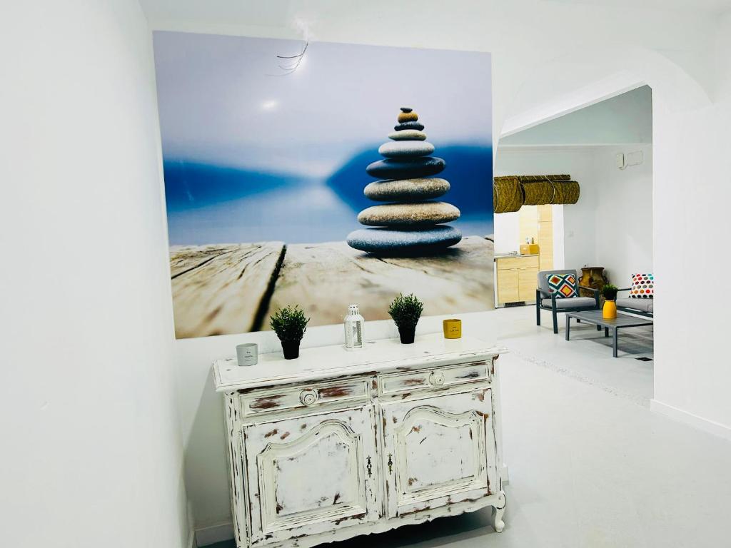 a room with a table with a picture of a stack of rocks at SOTAVENTO La Solera in Sanlúcar de Barrameda