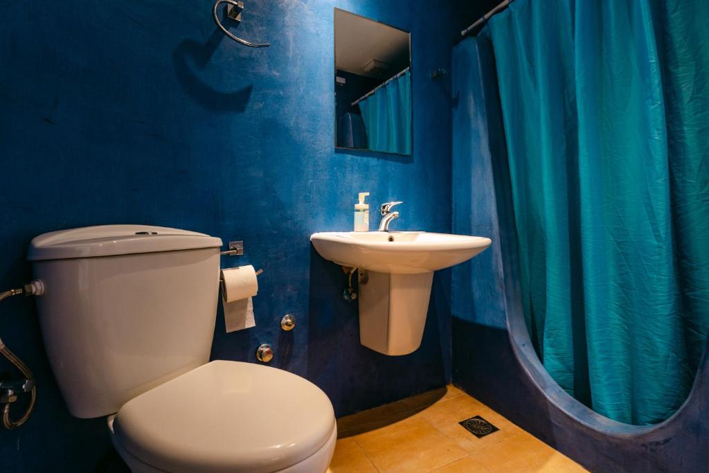 a blue bathroom with a toilet and a sink at Fanari Art in Ios Chora