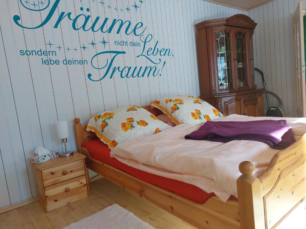 a bedroom with a bed with a sign on the wall at Landhauswohnung am Thüringer Meer mit Whirlpool-Fühlen wie Zuhause 