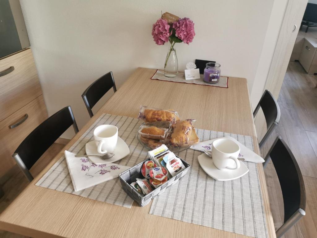 a table with two chairs and a table with pastries and cups at La casa de Nani in Porcen