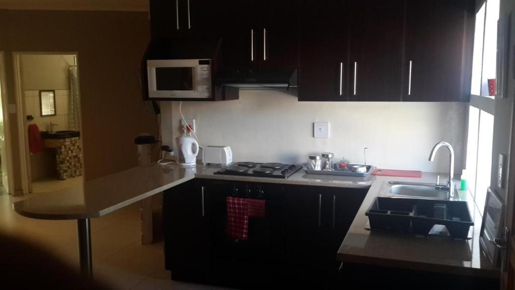 a kitchen with a sink and a counter top at Noble Luminous Accommodation and Tours in Rehoboth