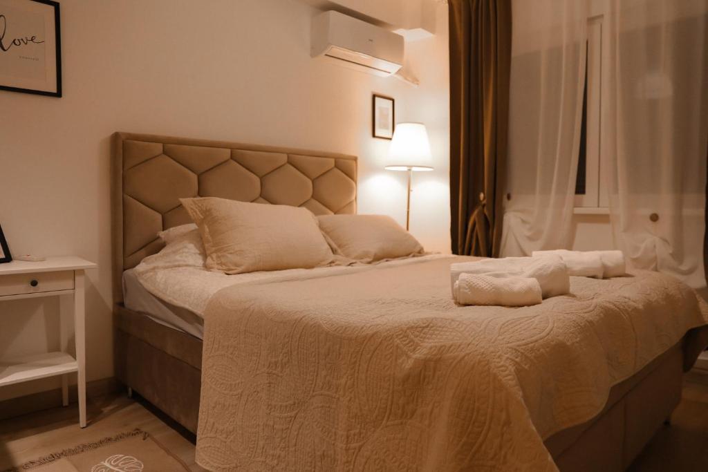 um quarto com uma cama com duas almofadas em Studio Paddock em Belgrado