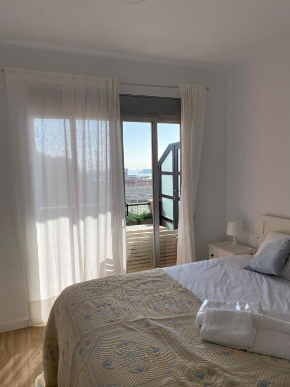 a bedroom with a bed and a large window at Frente al puerto y junto a la playa del Arenal in Burriana