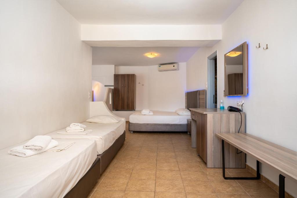 a hotel room with two beds and a bathroom at Fanari Art in Ios Chora
