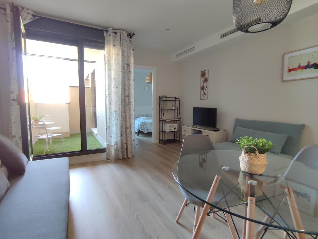 a living room with a couch and a table with chairs at Apartamento Servet, parking gratuito, a 5 minutos de Sevilla in Bormujos