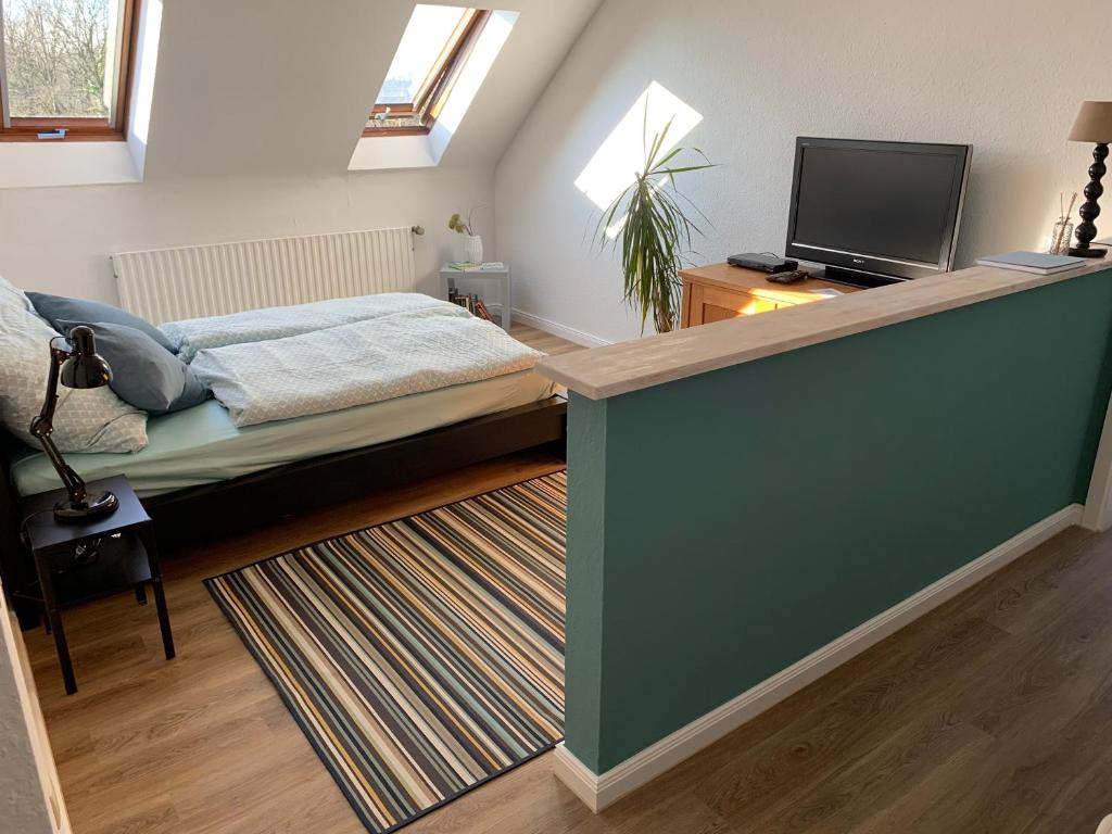 - une chambre avec un lit et une télévision à écran plat dans l'établissement Kleines Apartment in Mönchengladbach-Neuwerk, à Mönchengladbach
