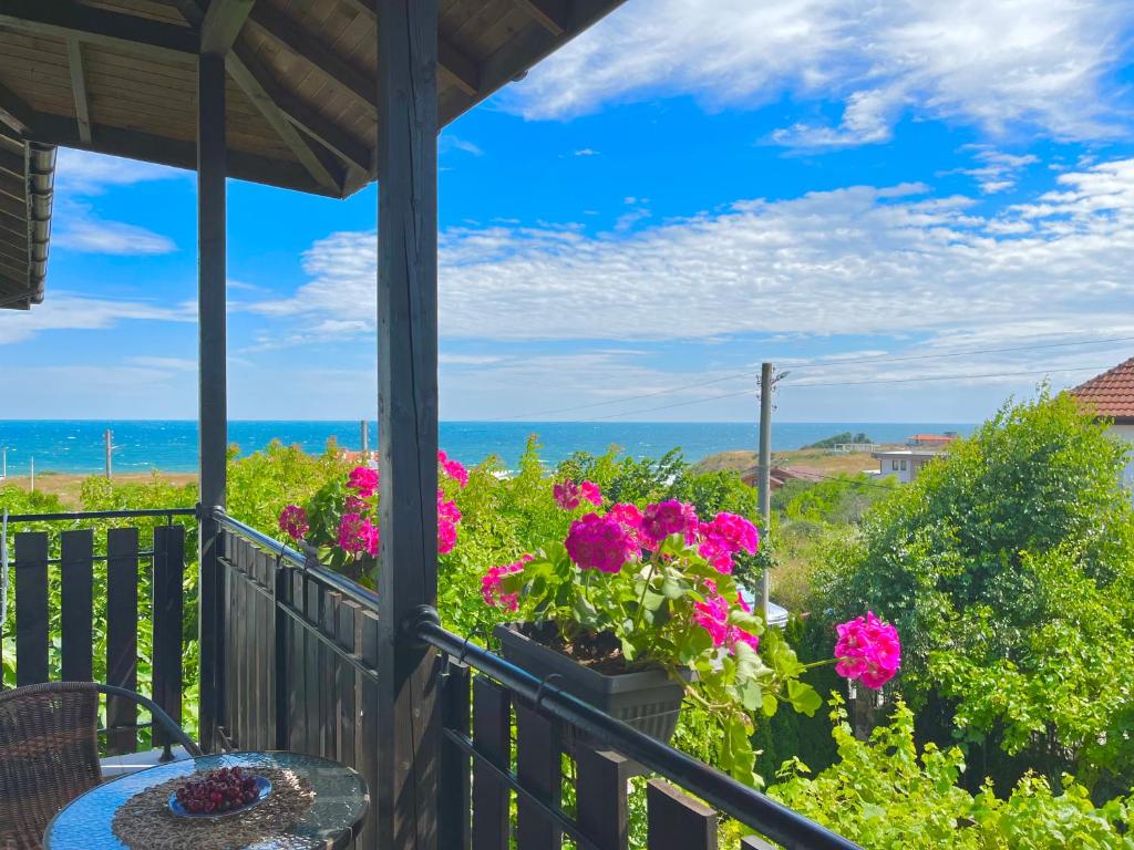 un porche con flores y vistas al océano en Villa Dimi, en Sinemorets