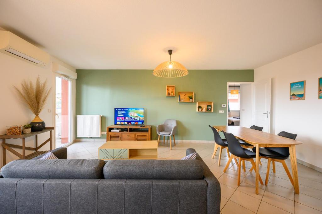 a living room with a couch and a table at Le Capeyron - Parking - WIFI - Aéroport in Mérignac
