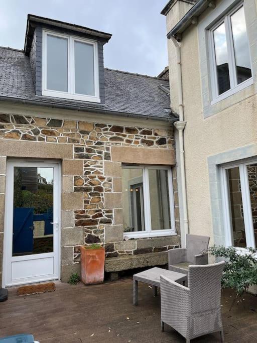 une maison en pierre avec une table et des chaises devant elle dans l'établissement Gîte du Port, à Ploubazlanec