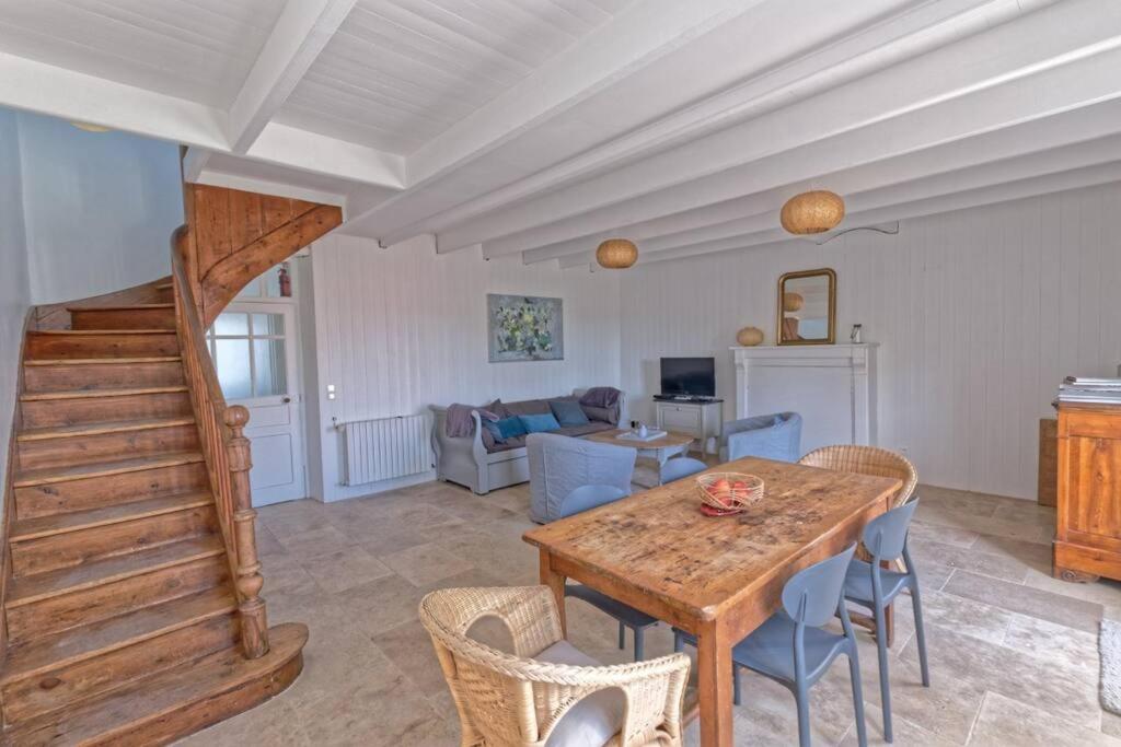 a living room with a wooden table and chairs at Le Gîte de Ker Ehden classé 3 étoiles in Ploubazlanec