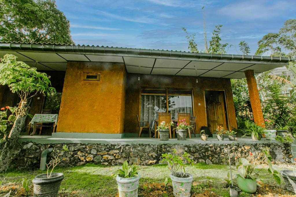 ein kleines Haus mit einer Steinmauer in der Unterkunft The Diary in Ella