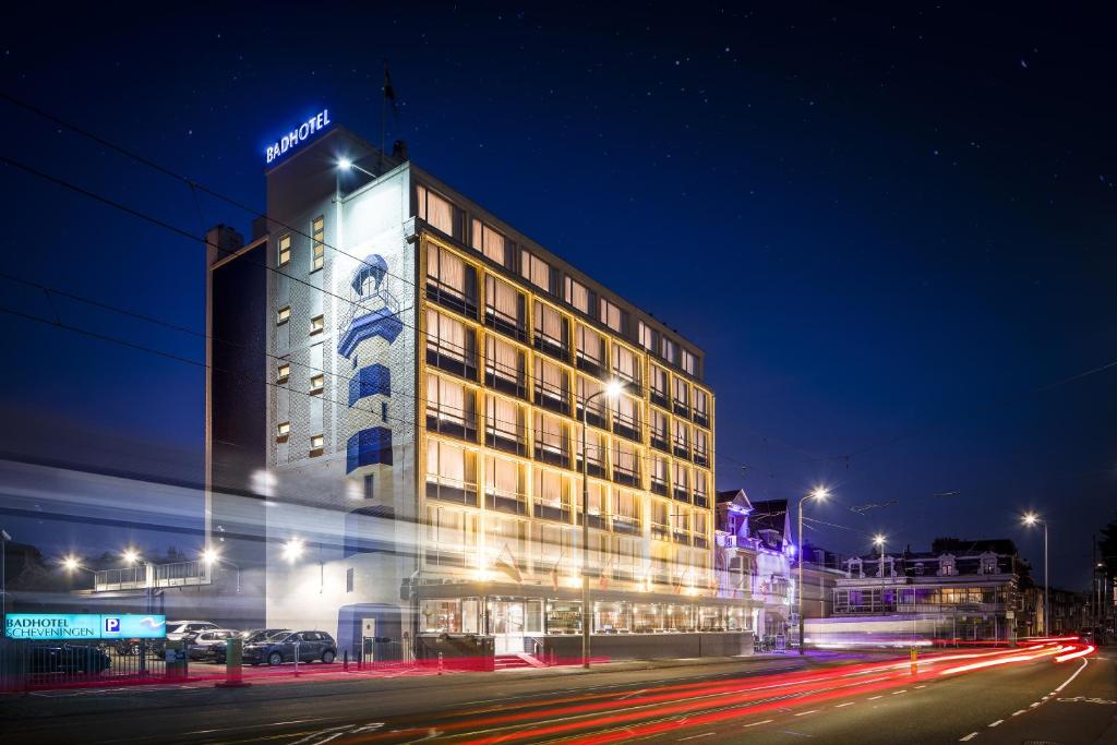 un bâtiment d'hôtel avec un panneau sur celui-ci la nuit dans l'établissement Badhotel The Hague Scheveningen, à Scheveningen