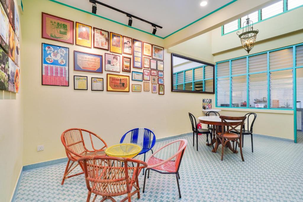 une salle à manger avec des tables, des chaises et des photos sur le mur dans l'établissement Dream & Wander Homestay, à Ipoh