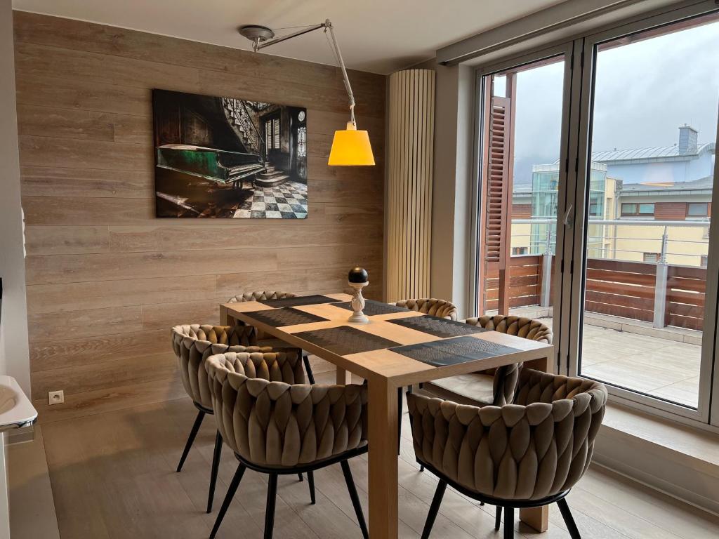 a dining room with a wooden table and chairs at Apartament ZETA - CITY 2 in Ustroń