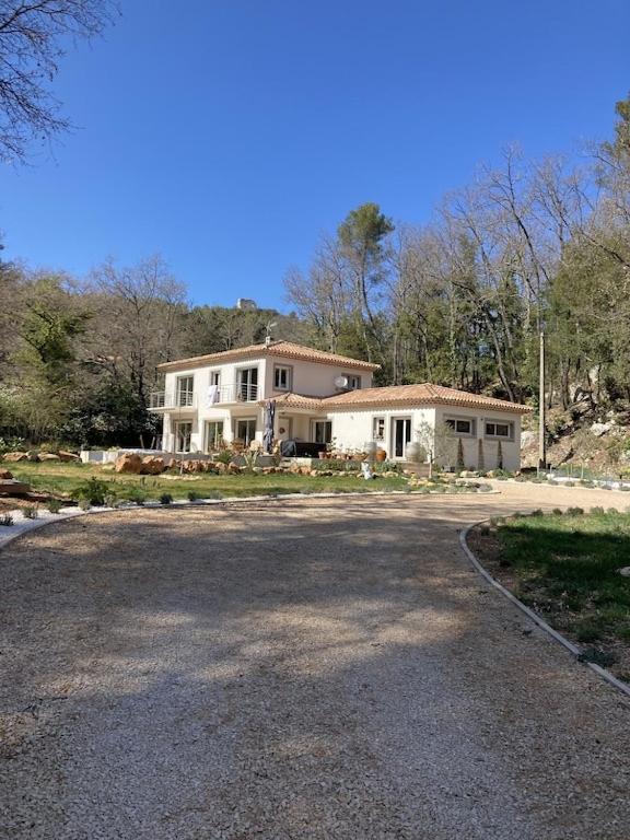 une grande maison assise sur le côté d'une route dans l'établissement Villa Martine, à Nans-les-Pins