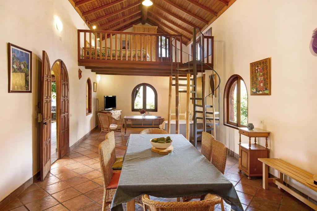 a dining room with a table and chairs and a staircase at Finca Los Dioses I in Mogán