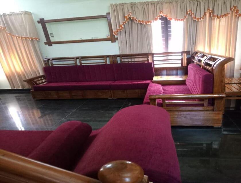 sala de estar con sillas moradas y sofá púrpura en Cloudnine Home Thrissur en Trichūr