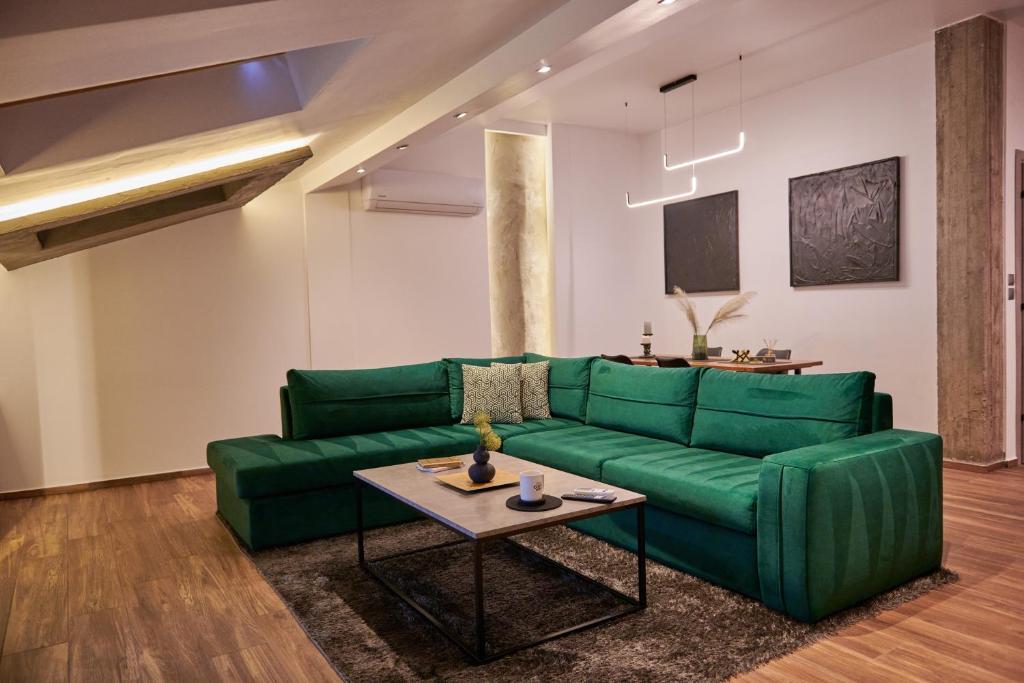 een woonkamer met een groene bank en een tafel bij The Skyline Suite in Florina