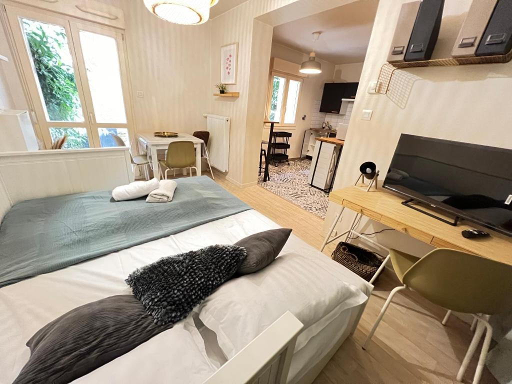 Dormitorio con cama, escritorio y TV en Le Standing Metz Un Séjour à Part, en Metz