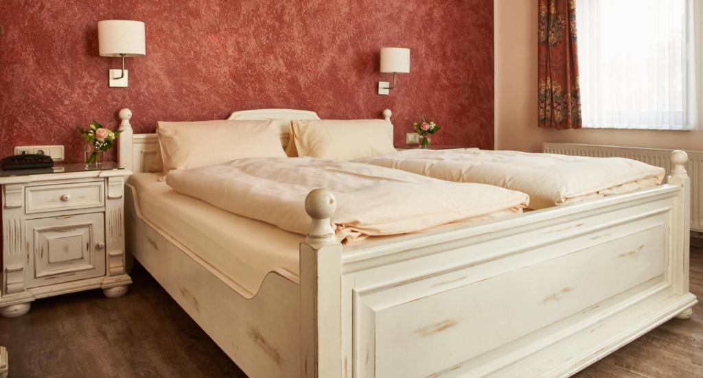 two white beds in a bedroom with red walls at Teichhotel in Schmalkalden