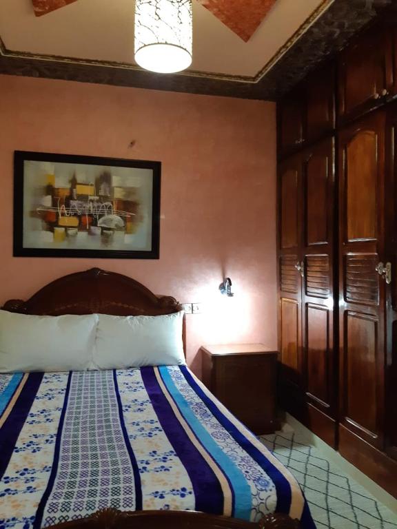 een slaapkamer met een bed met een blauwe en witte deken bij دوار السخينات in Es Skhinat