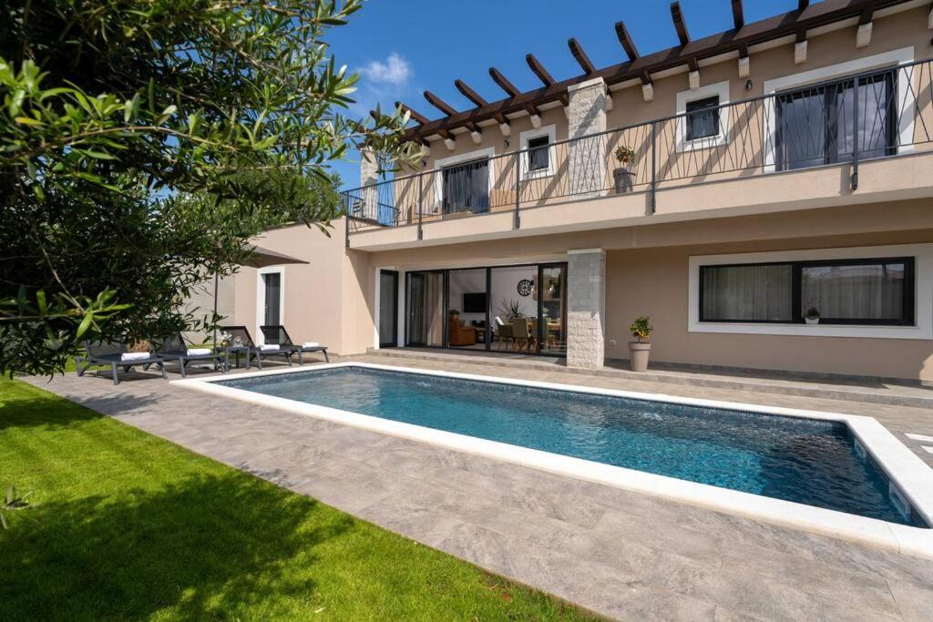 une villa avec piscine devant une maison dans l'établissement Casa Oliveto by Briskva, à Labin