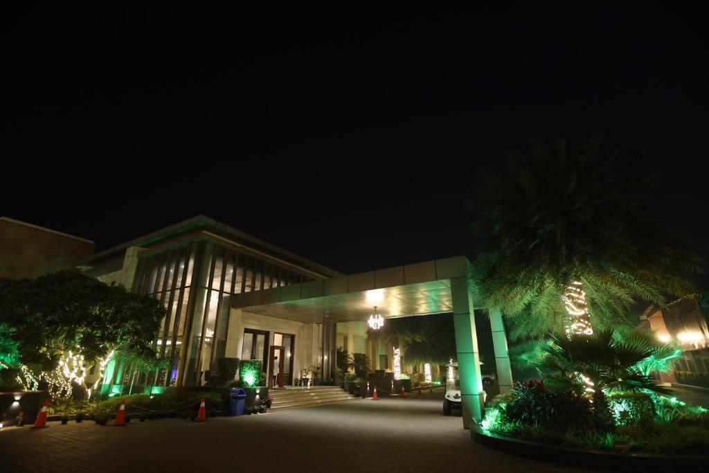 a building lit up at night with green lights at CALISTA RESORT in New Delhi