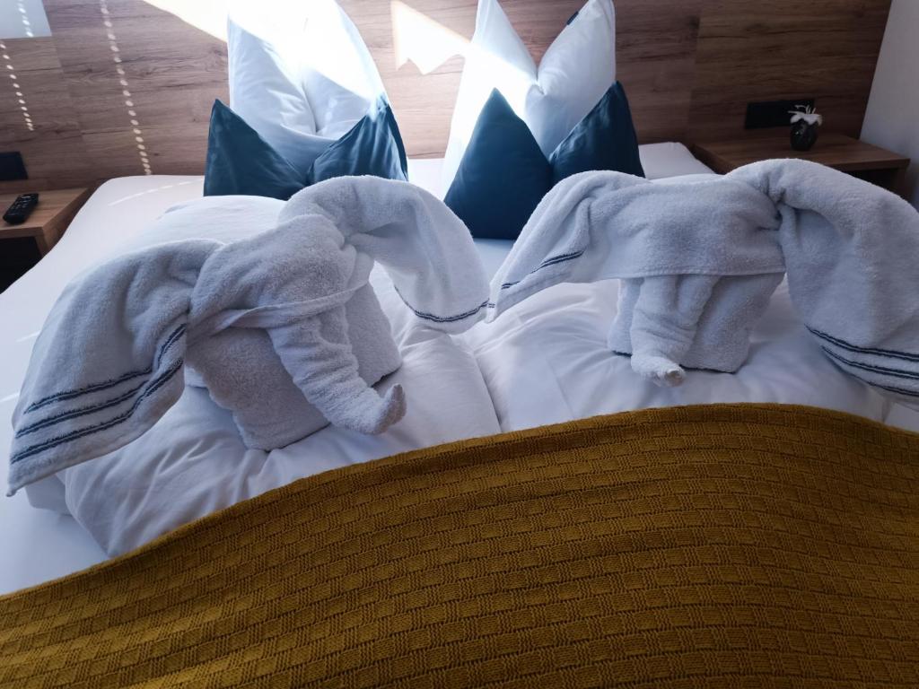 シュヴェンダウにあるAlpenoaseのベッドの上に横たわる二頭のぬいぐるみ