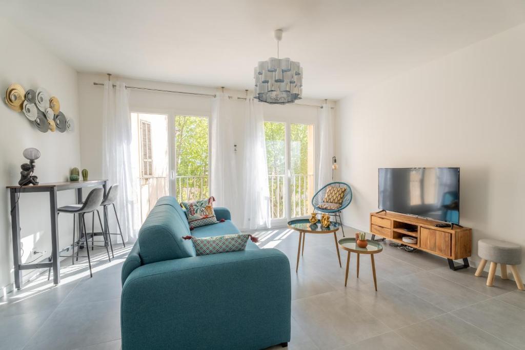 un salon avec un canapé bleu et une télévision dans l'établissement Modernity & Comfort Downtown Aix en Provence, à Aix-en-Provence