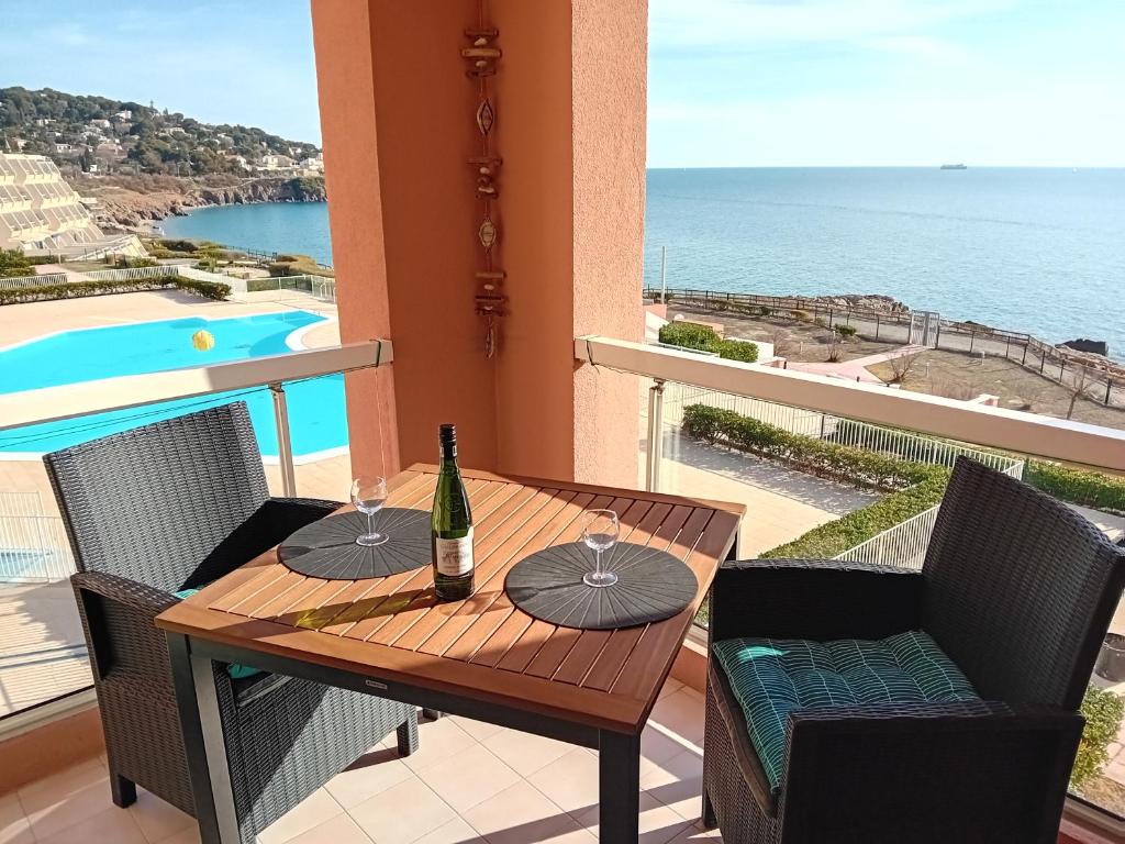 een tafel met twee glazen wijn op een balkon bij Escale Paradisiaque à Sète in Sète