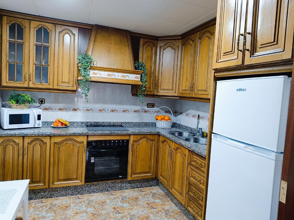 - une cuisine avec des placards en bois et un réfrigérateur blanc dans l'établissement Royal Luxe Terrace Sierra Subbetica, à Carcabuey
