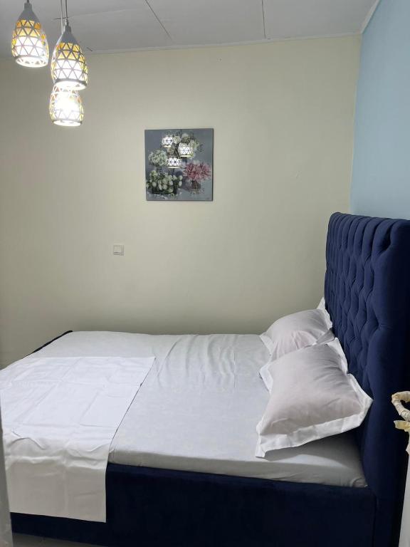 Bett mit blauem Kopfteil in einem Schlafzimmer in der Unterkunft Chez Astrid in Jaunde