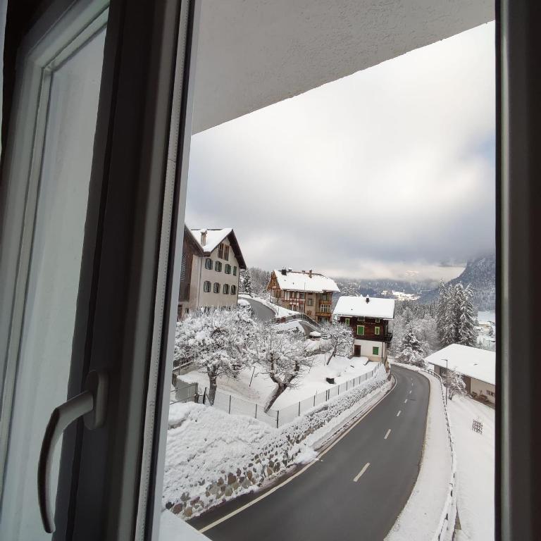 a view from a window of a snow covered road at Haus Albula in Alvaneu