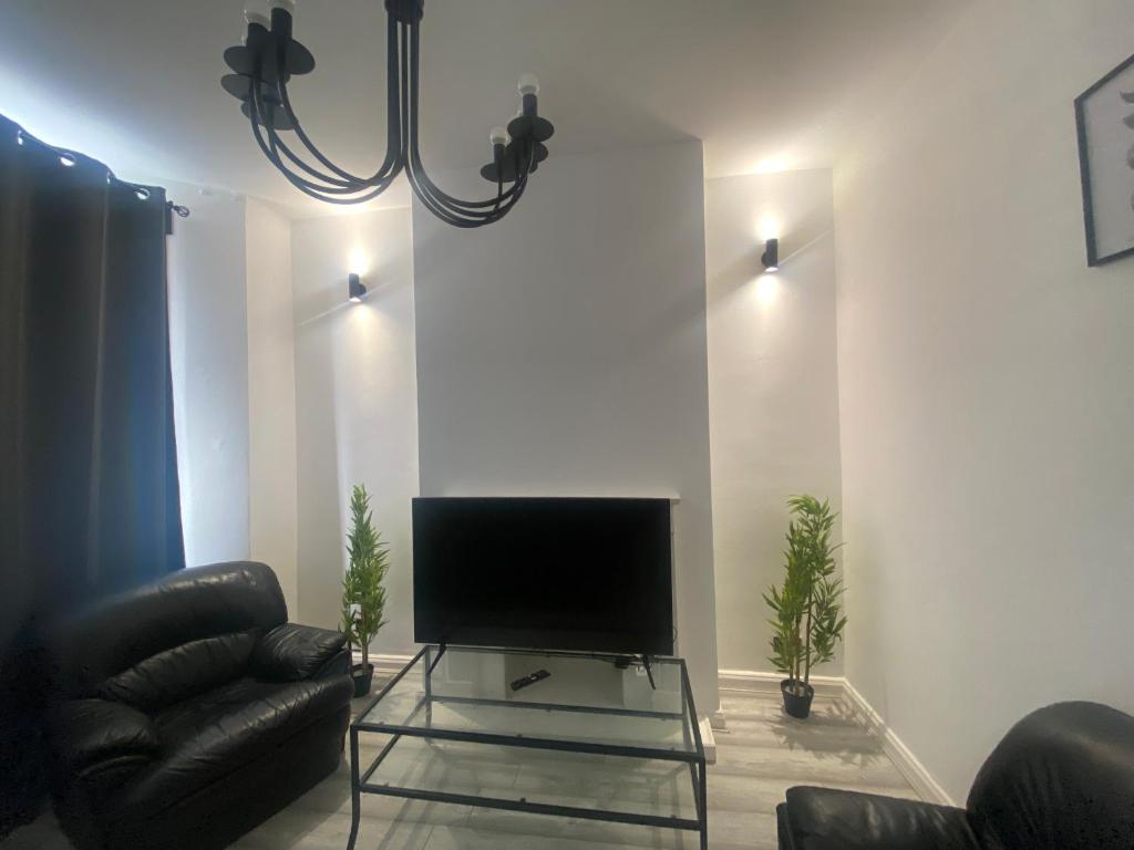 uma sala de estar com uma televisão de ecrã plano na parede em Spacious 3 Bed House London em Thornton Heath