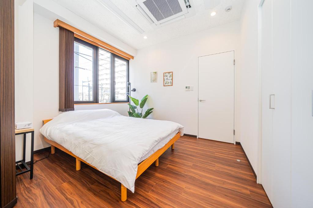a bedroom with a bed and a window at Skytree Apartment Self Check-in in Tokyo