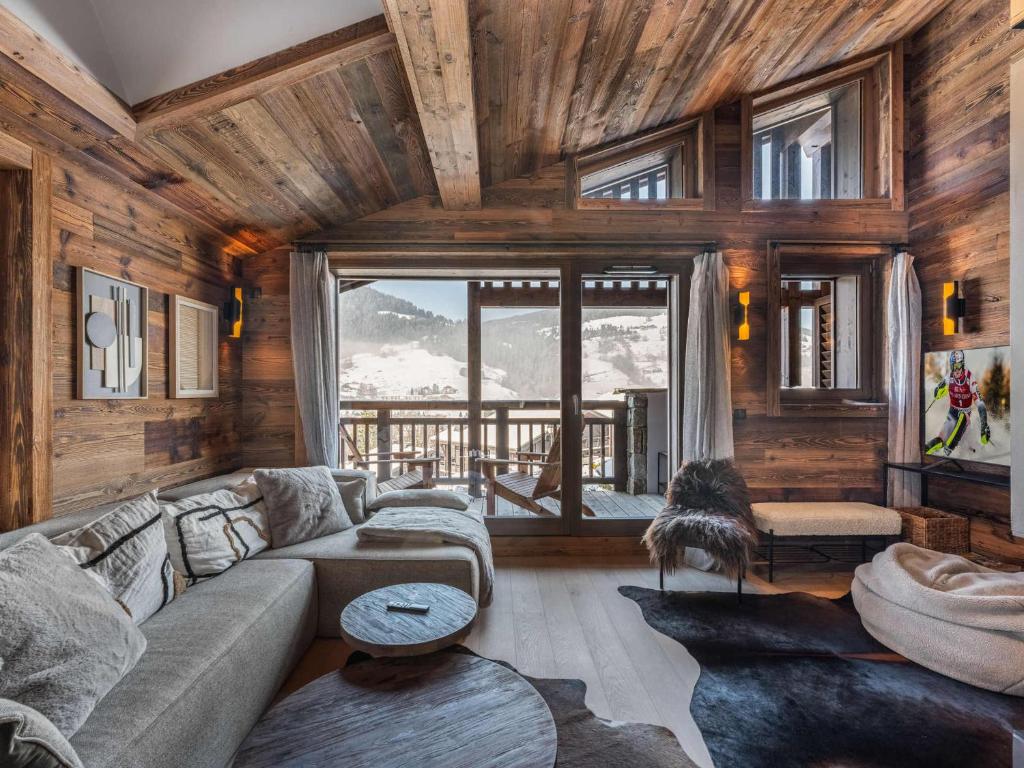 un salon avec un canapé et une grande fenêtre dans l'établissement Chalet avec spa partagé, 5 chambres, piscine, parkings à Megève - FR-1-569-187, à Megève