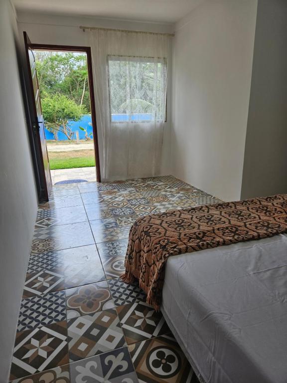sypialnia z łóżkiem i podłogą wyłożoną kafelkami w obiekcie Pousada On Home w mieście Búzios