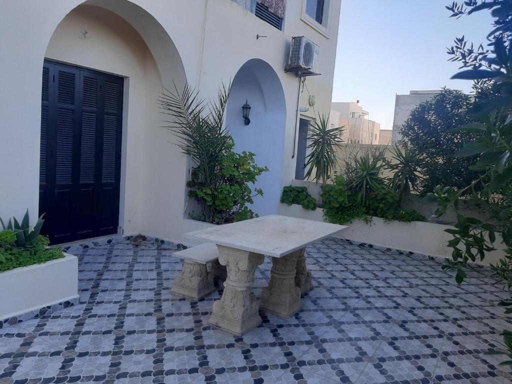 a stone bench sitting outside of a building at Coquet RDC in Borj el Khessous