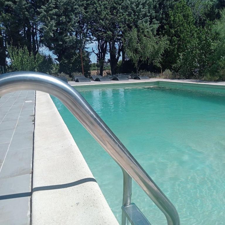 - une piscine d'eau bleue avec balustrade métallique dans l'établissement Chambre d'hôtes les garrigues, à Piolenc