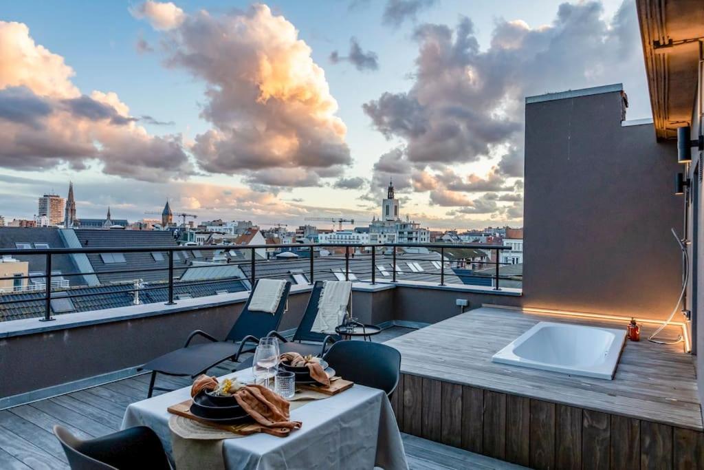een balkon met een tafel en stoelen met uitzicht op een stad bij Love Nest - Your cosy penthouse in Oostende