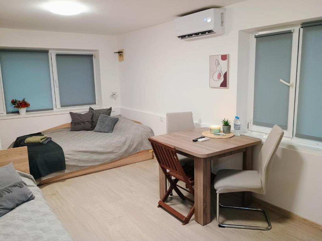 Habitación con cama, mesa y escritorio. en Болярска10, en Burgas
