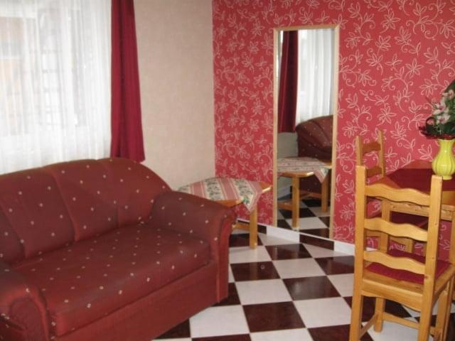 uma sala de estar com um sofá e um piso em xadrez em Andrea Apartmanház em Balatonlelle