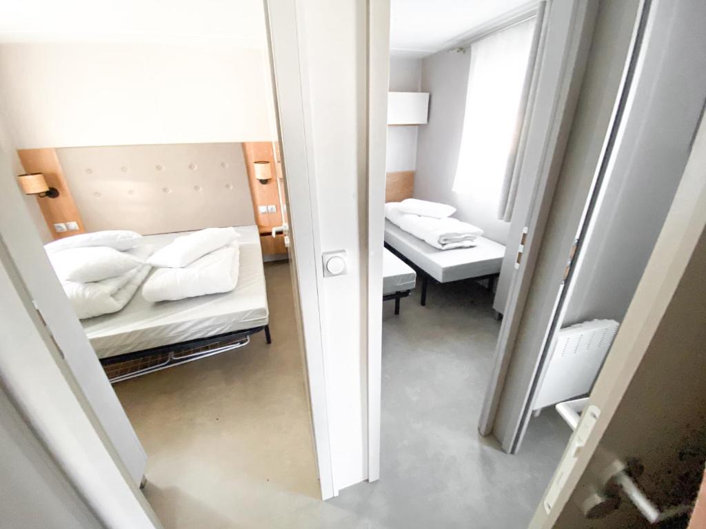 a small room with two beds and a mirror at Soleil Levant - Camping Belle-Vue in Berdorf
