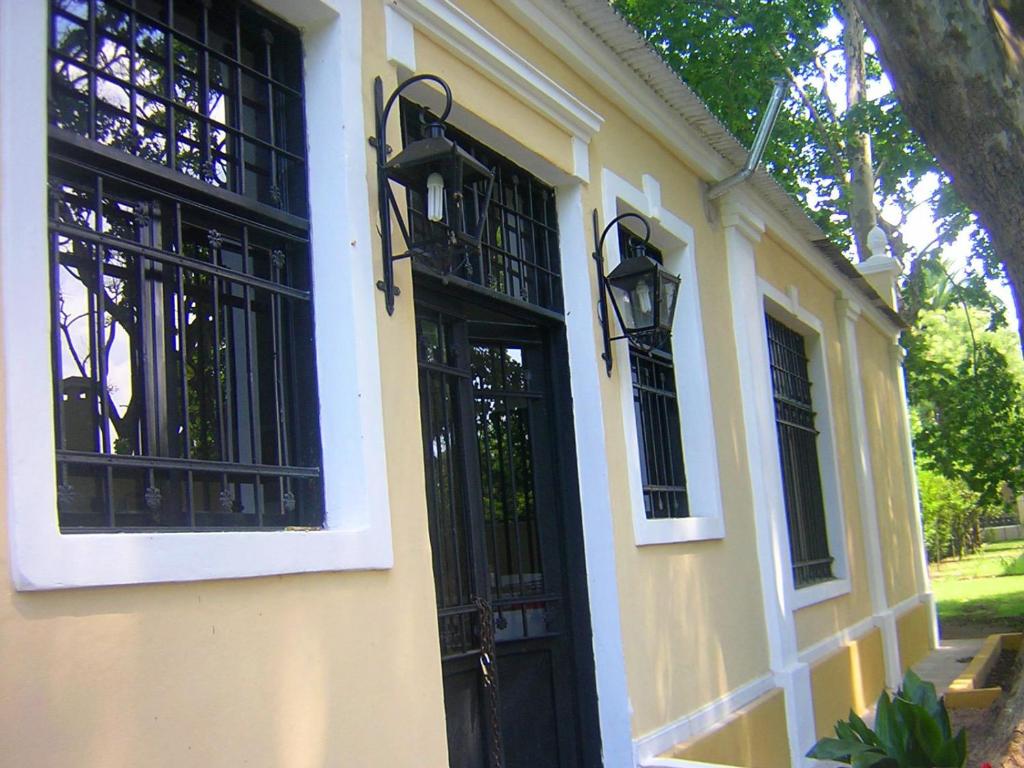 un edificio amarillo con una puerta y ventanas negras en Casa Huespedes en Hotel Villa Rosarito en Villa del Totoral