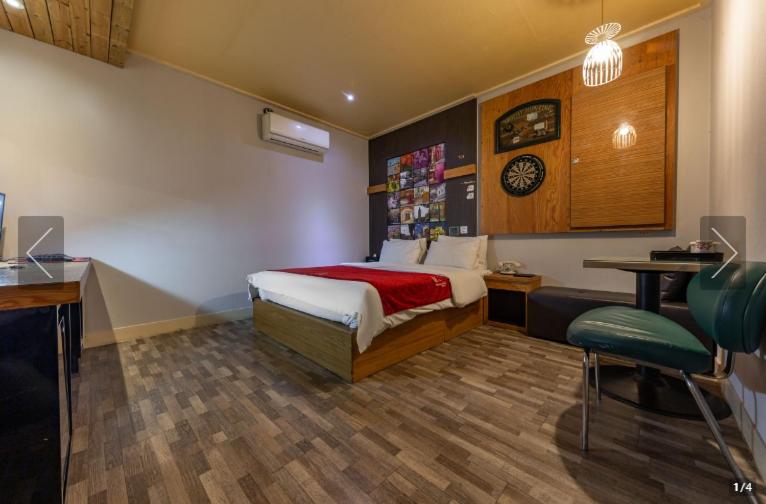 1 dormitorio con cama, escritorio y mesa en Dorothy Hotel en Cheonan