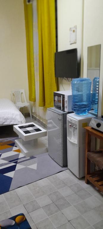 a living room with a tv and appliances in a room at Goldneststays in Nairobi