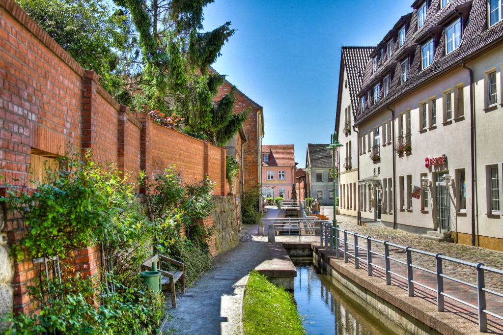 a canal in the middle of a city with buildings at Hotel am Markt Altentreptow in Altentreptow