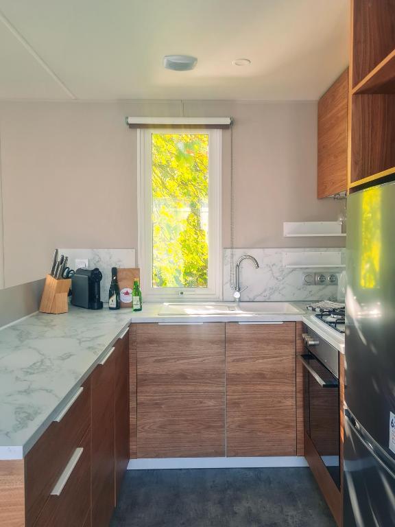 a kitchen with a sink and a window at Rêve d'été - Camping Belle-Vue 2000 in Berdorf