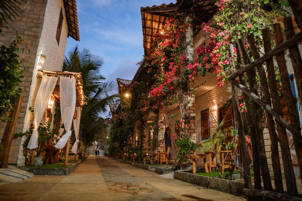 una calle estrecha con flores colgando de edificios en Pousada Villa Coqueiro, en Luís Correia
